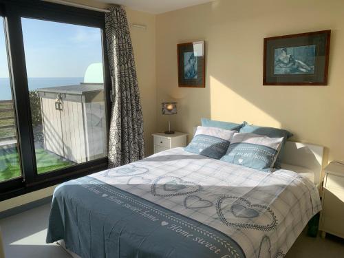 een slaapkamer met een bed en een groot raam bij Appartement Wimereux - Opaalkust met frontaal zeezicht in Wimereux