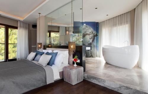 a bedroom with a large bed and a bath tub at Marti Hemithea Hotel in Orhaniye