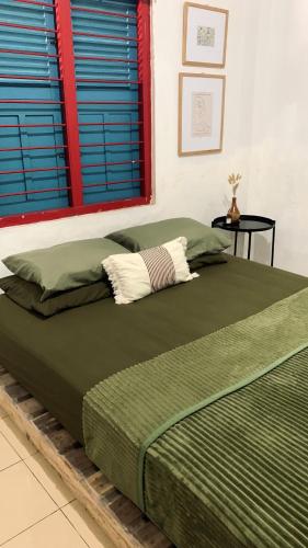 TimuranにあるDiwas Stayのベッドルームに緑の掛け布団付きのベッド1台