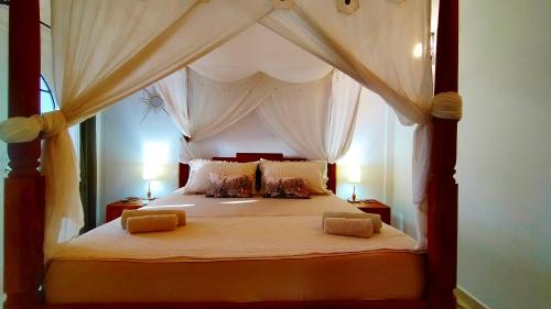 - une chambre avec un lit à baldaquin et 2 lampes dans l'établissement Caleta Beach House, à Caleta de Fuste