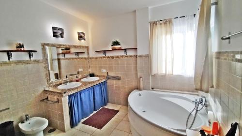 La salle de bains est pourvue de 2 lavabos et d'une baignoire. dans l'établissement Caleta Beach House, à Caleta de Fuste
