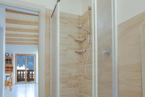 La salle de bains est pourvue d'une douche et d'un mur en bois. dans l'établissement Sas Lonch, à Pera