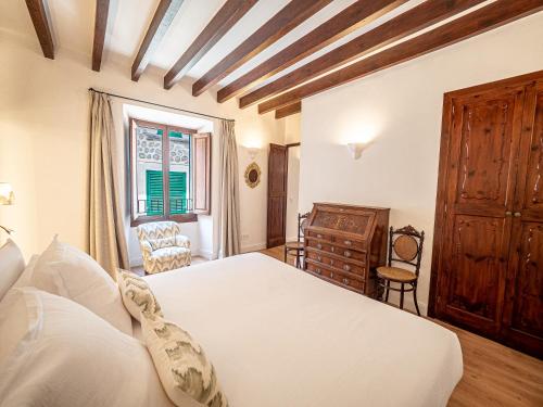 a bedroom with a bed and a dresser and a window at Ca'n Puig de Sòller in Sóller