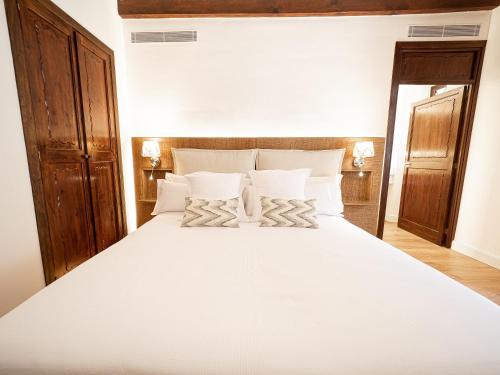 a bedroom with a large white bed with white pillows at Ca'n Puig de Sòller in Sóller