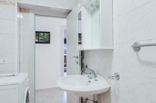 a white bathroom with a sink and a mirror at Ciampedie in Pera