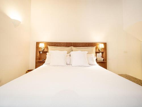 a bedroom with a white bed with two pillows at Ca'n Puig de Sòller in Sóller