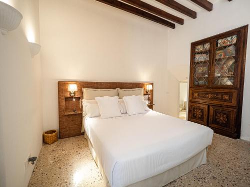 a bedroom with a large white bed with white pillows at Ca'n Puig de Sòller in Sóller