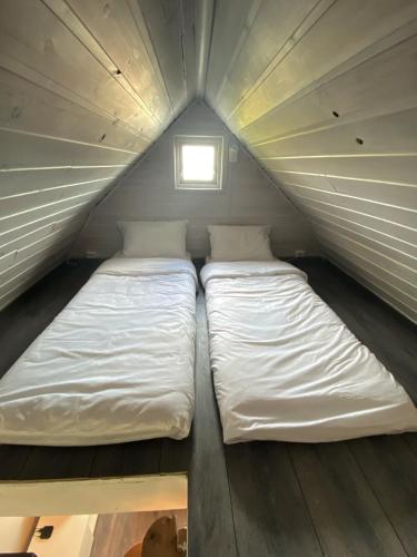 two beds in a tiny house with a window at Lille huset in Holmestrand