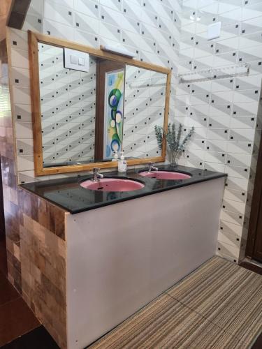 a bathroom with two sinks and a mirror at vintage valley urban cottage in Thodupuzha