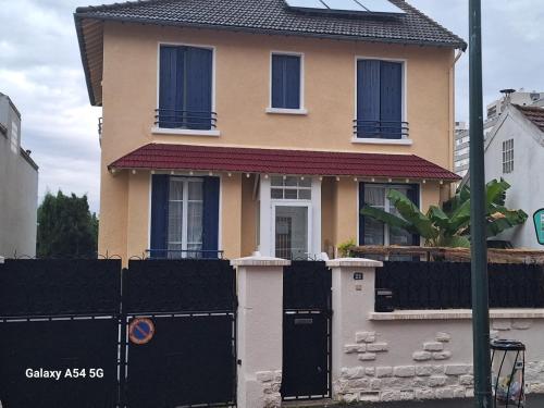 a house with a black fence in front of it at Studio équipé proche Stade de France in Épinay-sur-Seine