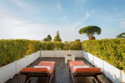 a patio with chairs and a table and a hedge at Jumeirah Capri Palace in Anacapri