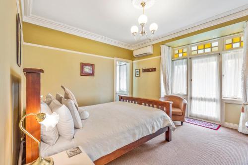 a bedroom with a large bed with white pillows at Bethany Manor Bed & Breakfast in Leura