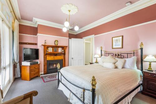 sypialnia z łóżkiem i kominkiem w obiekcie Bethany Manor B&B call them for Guaranteed Cheapest Price w mieście Leura