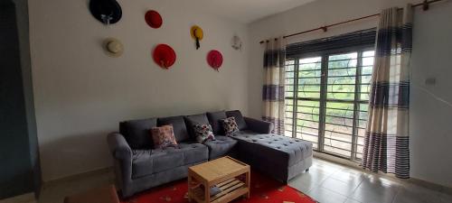 a living room with a couch and a window at Lavila. Fully furnished 2 bedroomed house. Located in busukuma, wakiso Uganda. in Gayaza