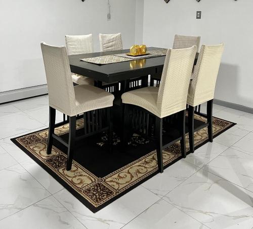 a black dining room table with white chairs on a rug at Luxury Guest House - Cheap JFK Pick up & Drop Off Available in Jamaica