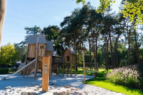un parco con parco giochi in legno e scivolo di Vakantiepark Molenvelden a Veldhoven