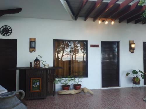 a room with potted plants on the floor and a window at Beach House at Carolina del Mar in Samboan