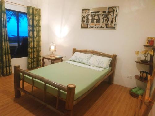 a bedroom with a bed and a window at Beach House at Carolina del Mar in Samboan
