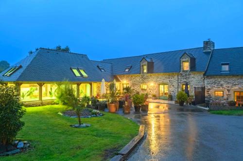 a large stone house with a yard at Les Pierres Bleues in Saint-Coulitz