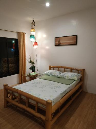 a bedroom with a bed with a wooden frame at Beach House at Carolina del Mar in Samboan