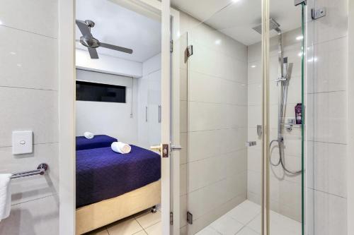 a small bathroom with a shower and a bed at Darwin City - The Oaks with Harbour Views in Darwin