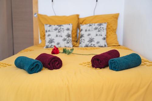 a bed with three knitted pillows on it at L'Escapade-Spacieux -Climatisation-Centre Ville in Montélimar