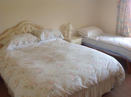 a bedroom with a bed with a floral comforter at Estuary View Farm in Kingsbridge