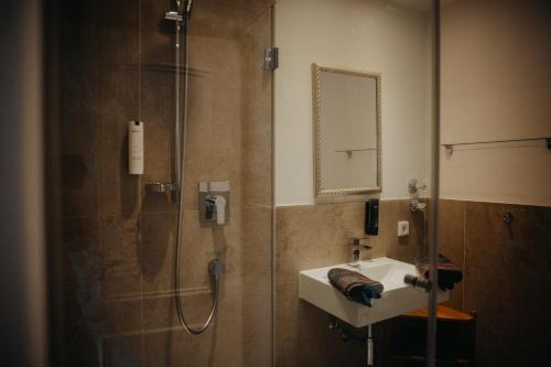 a bathroom with a shower and a sink and a mirror at Salzbergalm in Berchtesgaden