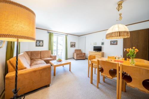 a living room with a couch and a table at 4402 Geraeumige, zweckmaessig eingerichtete Maisonette-Wohnung mit mit Blick auf die Villa Engiadina in Vulpera