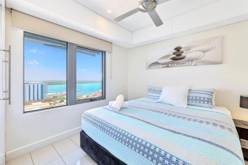 a bedroom with a bed with a view of the ocean at Darwin City - The Oaks with Harbour Views in Darwin