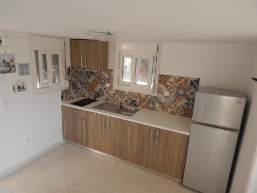 a kitchen with wooden cabinets and a refrigerator at Epiphany Apartments in Karpathos Town
