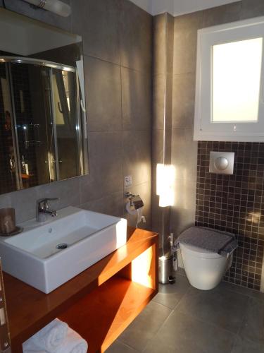 a bathroom with a white sink and a toilet at Epiphany Apartments in Karpathos
