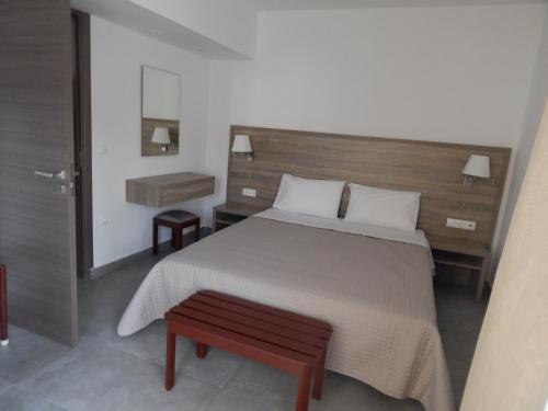 a bedroom with a large bed with a wooden headboard at Epiphany Apartments in Karpathos Town