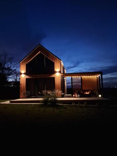 a house with lights on the side of it at night at Okno Na Ślężę in Sady