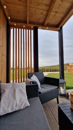 a screened in porch with a couch and a grill at Okno Na Ślężę in Sady