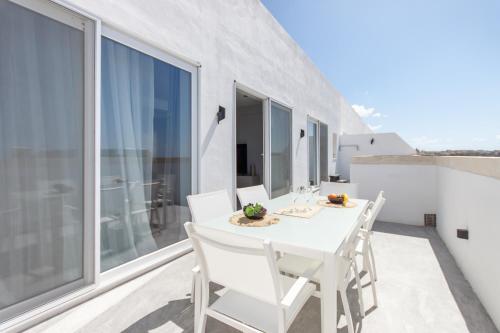 沙拉的住宿－Seaview And Wellness Penthouse In Gozo - Happy Rentals，阳台上配有白色的桌椅