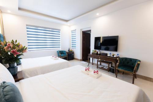 een woonkamer met 2 bedden en een televisie bij Royal Hotel Sài Đồng - Long Biên in Hanoi