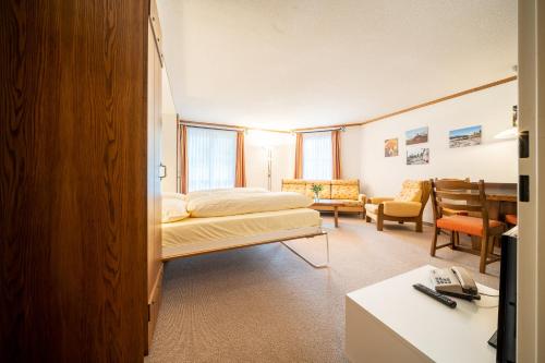 1 dormitorio con 1 cama y sala de estar en 6304 Preislich attraktives Studio mit Suedbalkon am Wanderweg en Vulpera