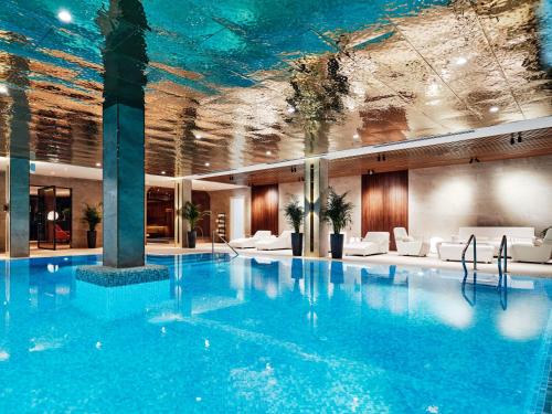 een zwembad in een hotel met een plafond bedekt met algen bij Crowne Plaza Tashkent, an IHG Hotel in Tasjkent