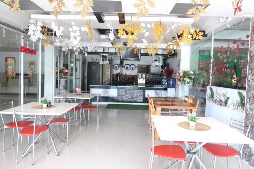 a restaurant with white tables and red chairs at COCOS HOTEL in Compostela