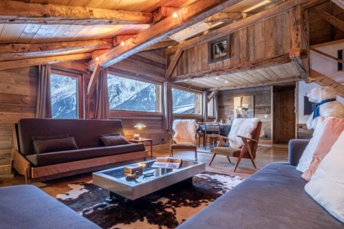 un salon avec un canapé et une table dans l'établissement Authenthic Chalet Ski on Les Houches Chamonix, aux Houches