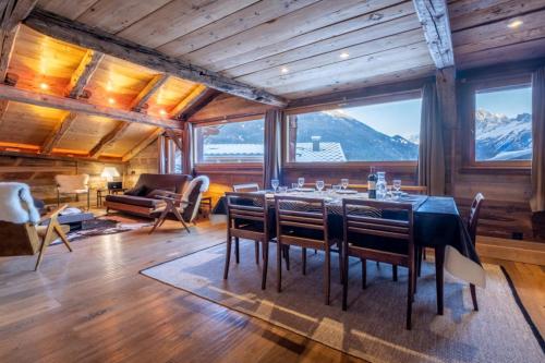ein Esszimmer mit einem Tisch, Stühlen und Bergen in der Unterkunft Authenthic Chalet Ski on Les Houches Chamonix in Les Houches