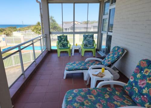 a balcony with chairs and a table and chairs at Casa Uvongo 110 in Uvongo Beach