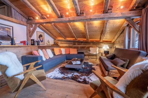 un salon avec un canapé bleu et des chaises dans l'établissement Authenthic Chalet Ski on Les Houches Chamonix, aux Houches