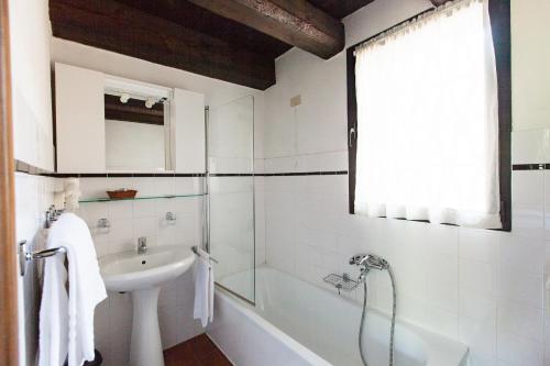 a white bathroom with a sink and a tub and a shower at Villa Di Tissano in Tissano