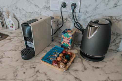 - un comptoir avec une cafetière et une boîte de biscuits dans l'établissement Apartmány Kurovický lom, 