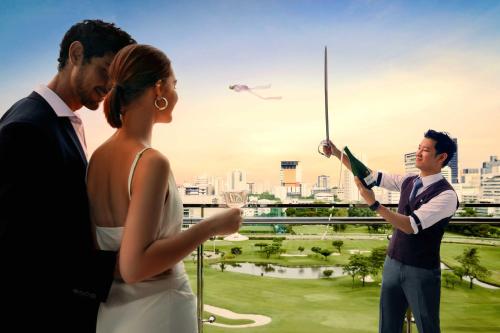 a bride and groom looking at a kite in the sky at The St. Regis Bangkok in Bangkok