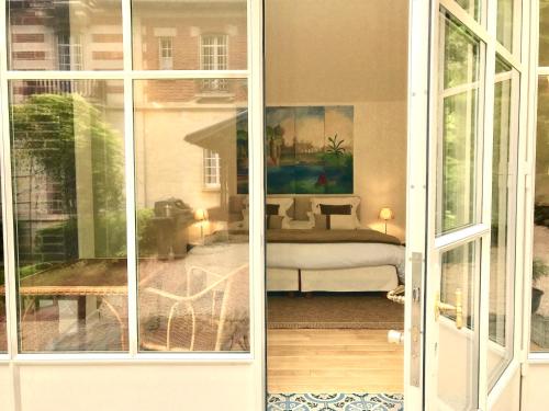 Blick auf ein Schlafzimmer durch eine Glasschiebetür in der Unterkunft Villa du Châtelet in Choisy-au-Bac