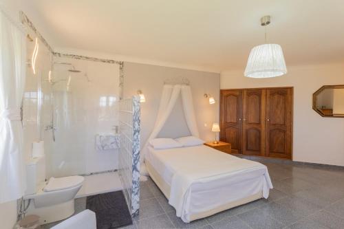 - une chambre avec un lit blanc et une douche dans l'établissement Villa Petalas de Amor V063, à Lagos