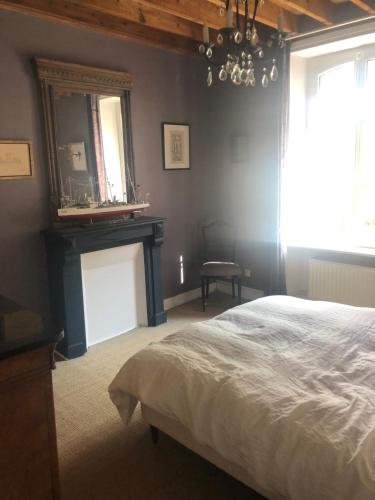 sypialnia z łóżkiem i lustrem na ścianie w obiekcie Mon Plaisir de Carteret w mieście Barneville-Carteret